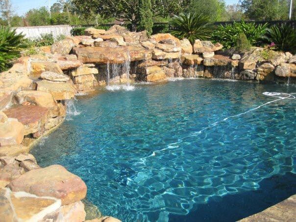 A large swimming pool with a waterfall in the middle