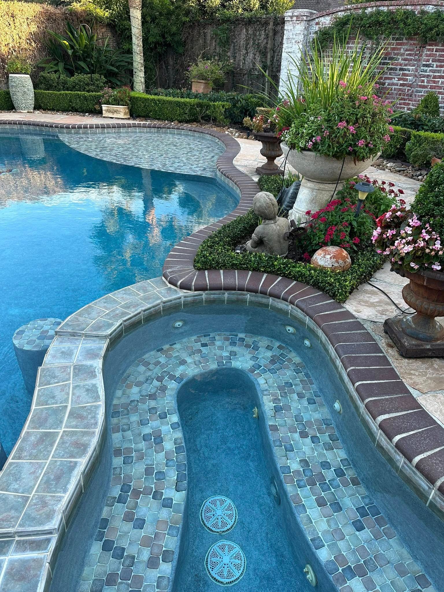 A large swimming pool with a hot tub in the middle of it.