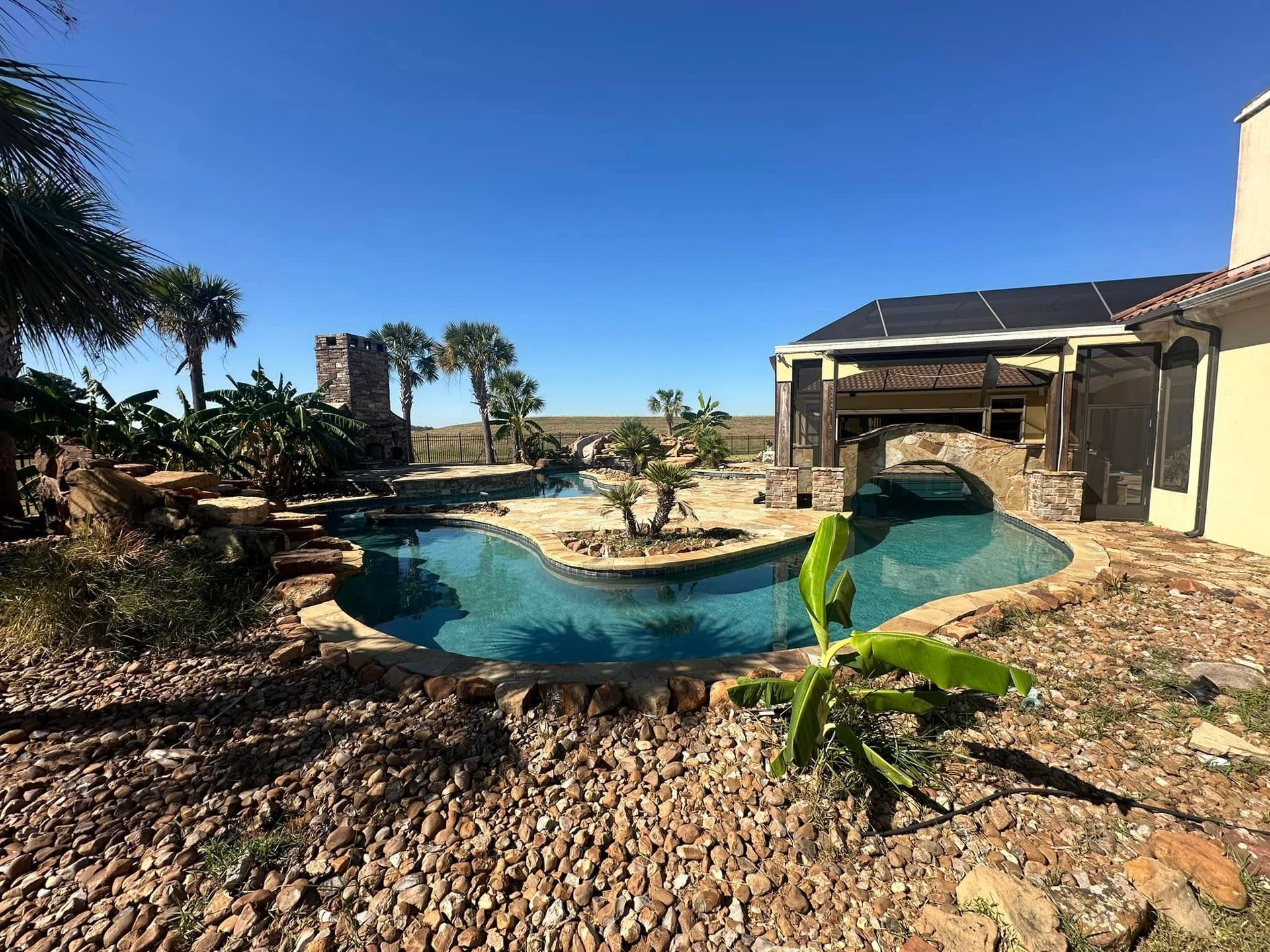 There is a large swimming pool in the backyard of a house.