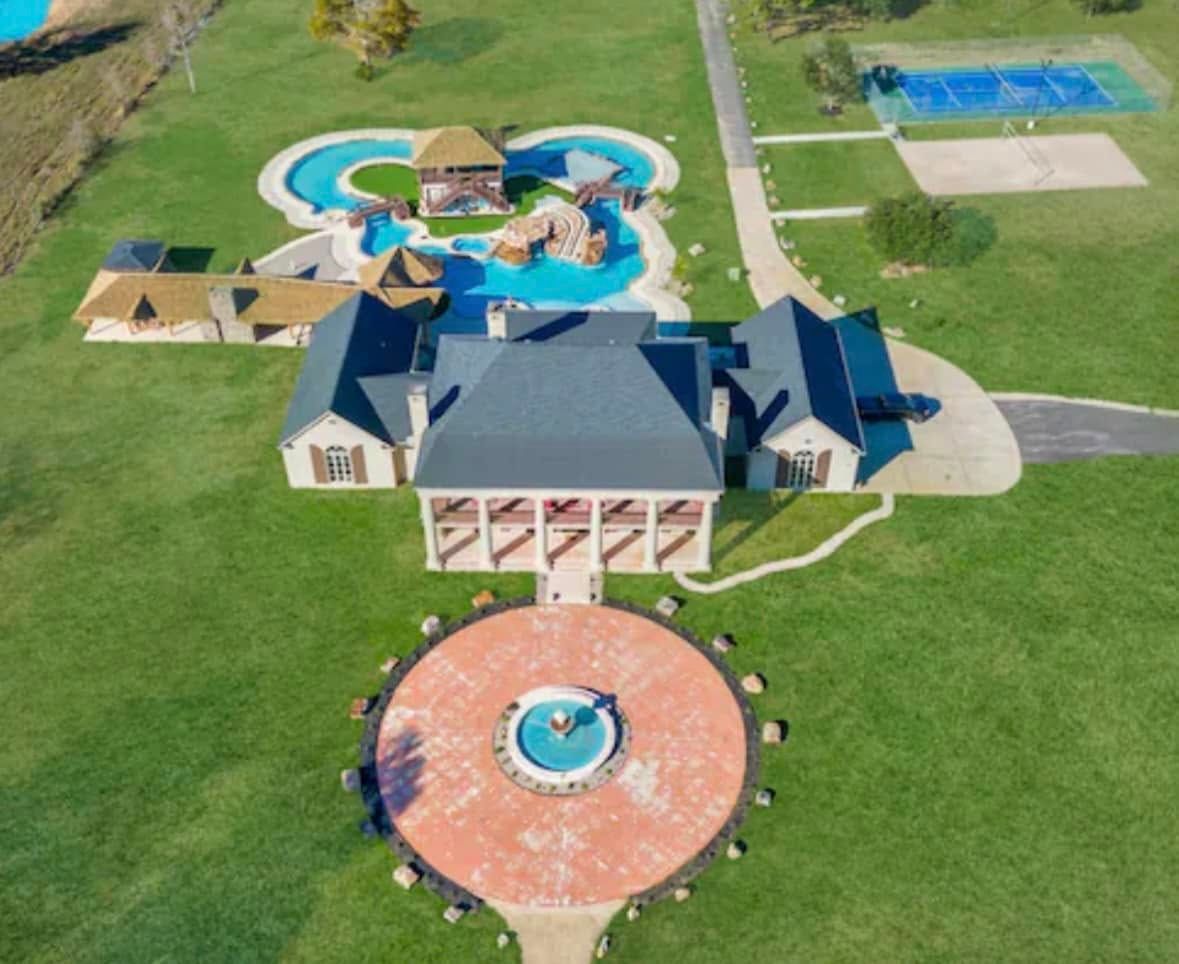 An aerial view of a large house with a pool