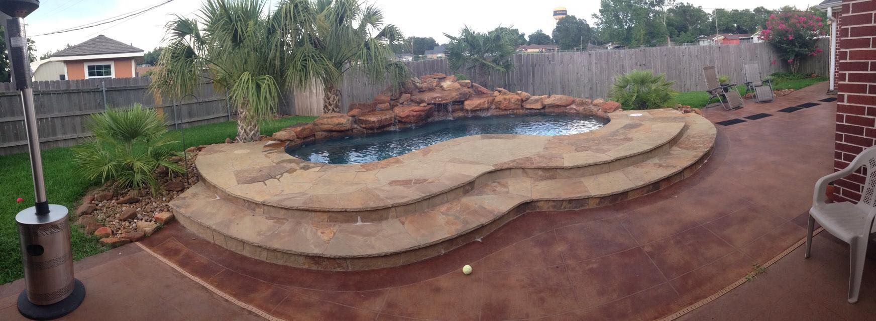 A large swimming pool in the backyard of a house.