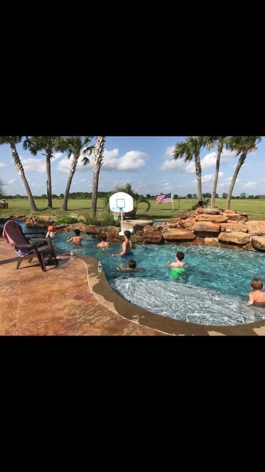 A group of people are swimming in a large swimming pool.