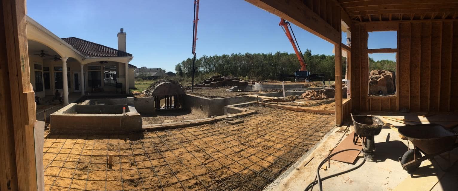 A panoramic view of a house under construction with a crane in the background.
