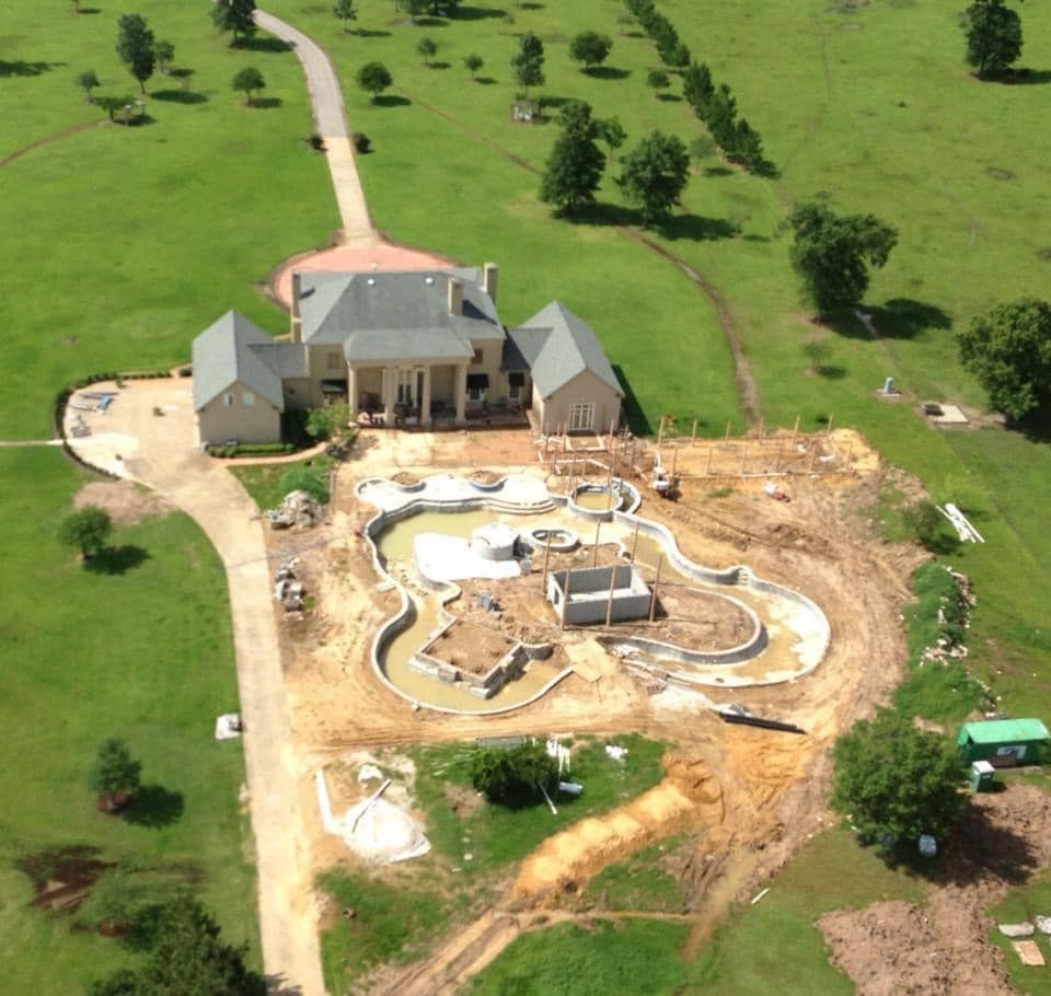 An aerial view of a house under construction with a pool