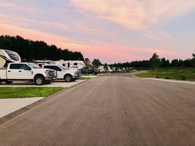 a row of white trucks parked on the side of a road .