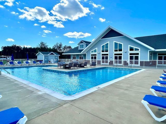 a large swimming pool in front of a large house