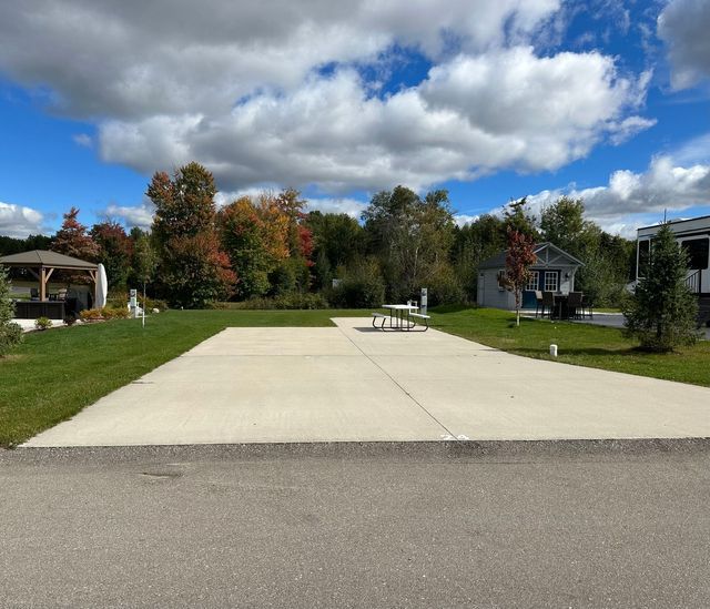 a concrete driveway with a picnic table in the middle of it .