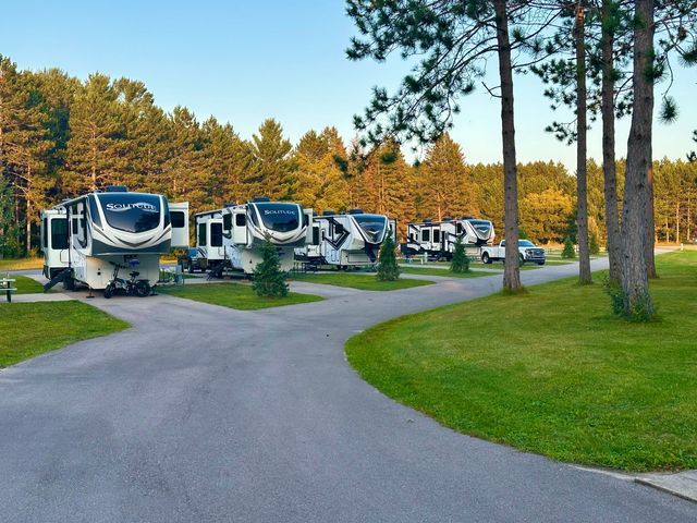 a row of rv 's are parked on the side of a road .