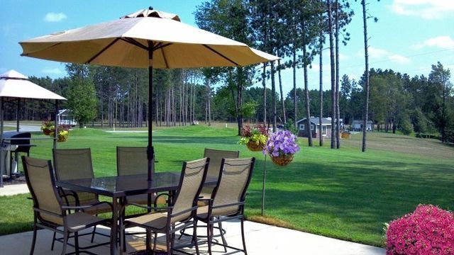 a table and chairs under an umbrella on a patio