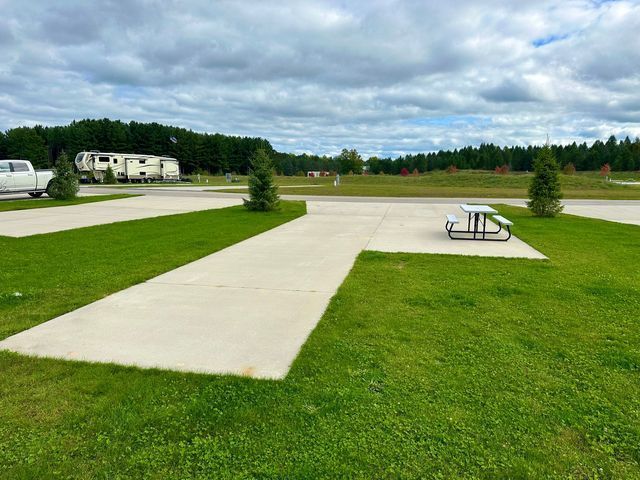 there is a picnic table in the middle of the grass .