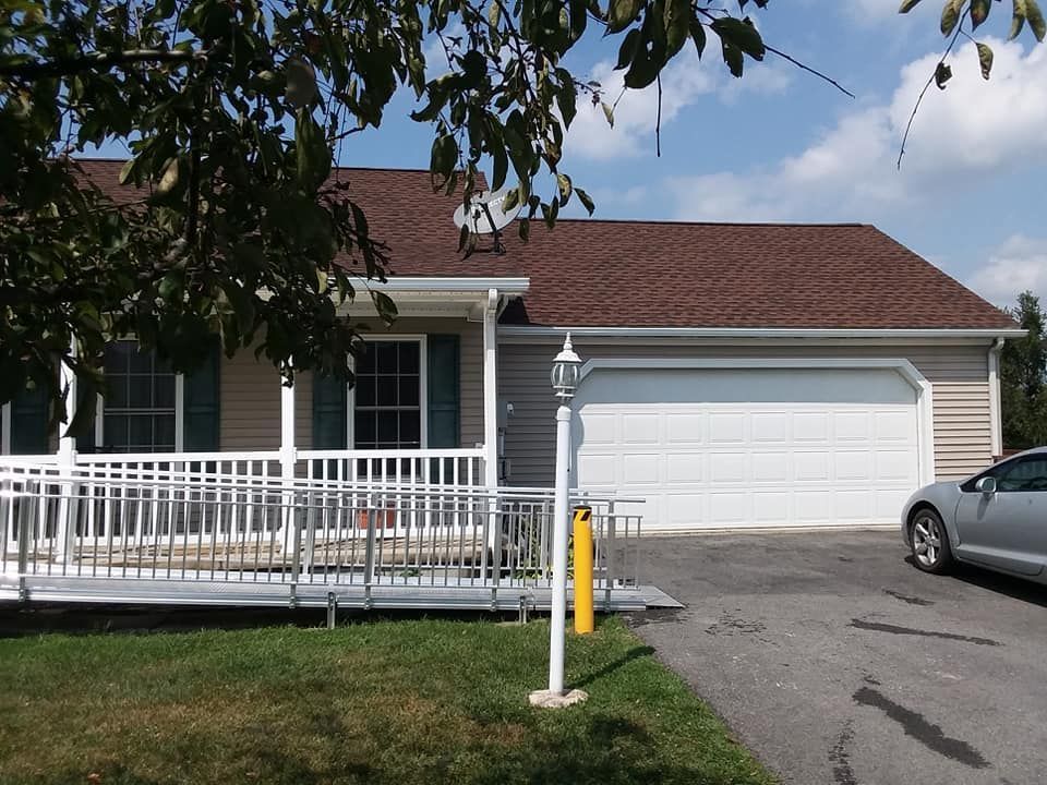 A car is parked in front of a house with a ramp