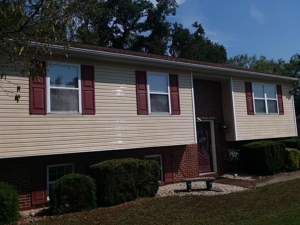 A house with red shutters and a bench in front of it