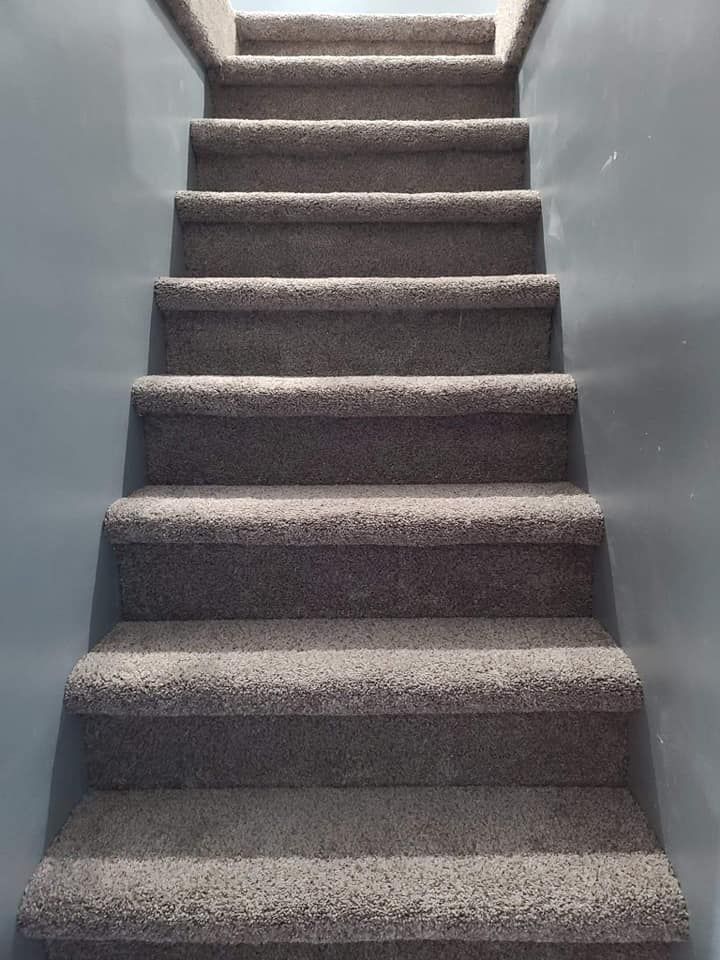 A set of carpeted stairs leading up to the second floor of a house.