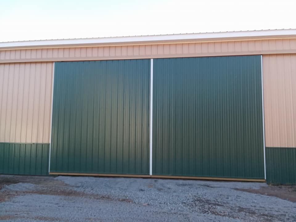 A green and tan building with a large sliding door