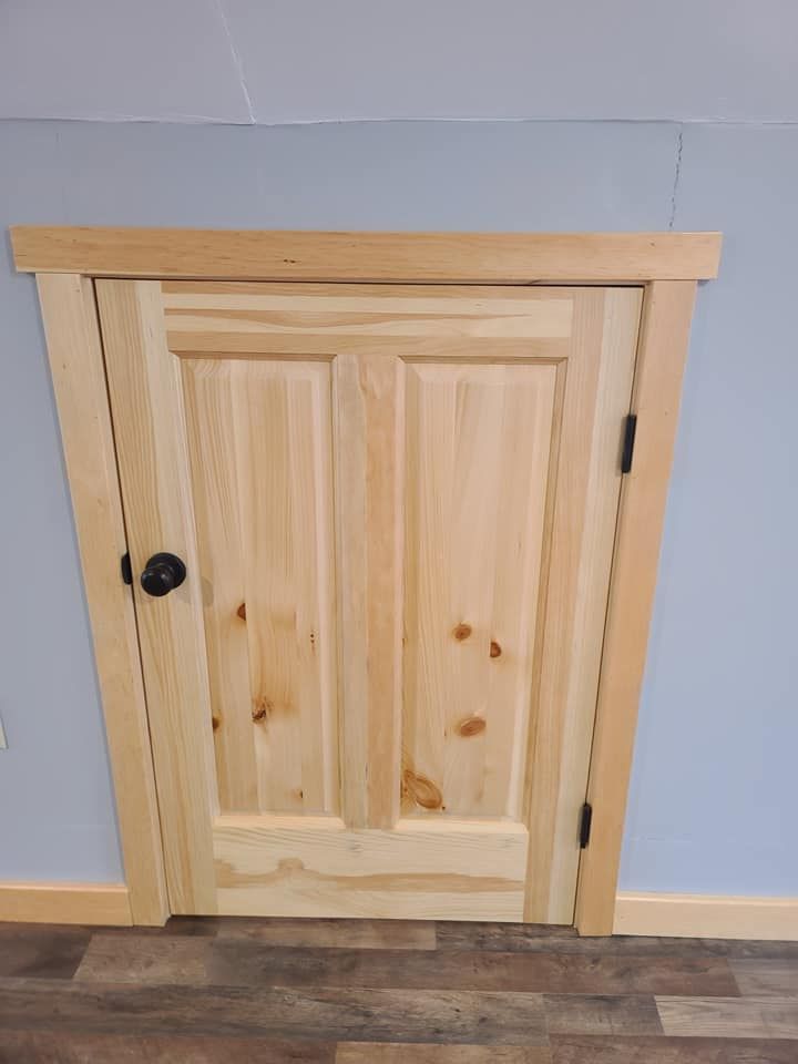 A wooden door in a room with a wooden floor.