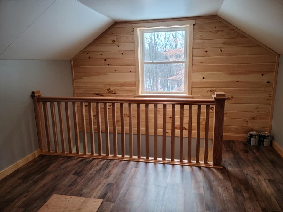 An empty room with a wooden railing and a window
