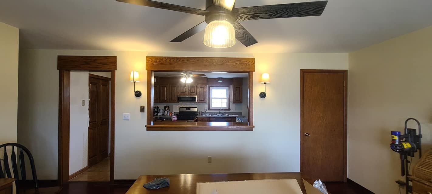 A living room with a ceiling fan and a table
