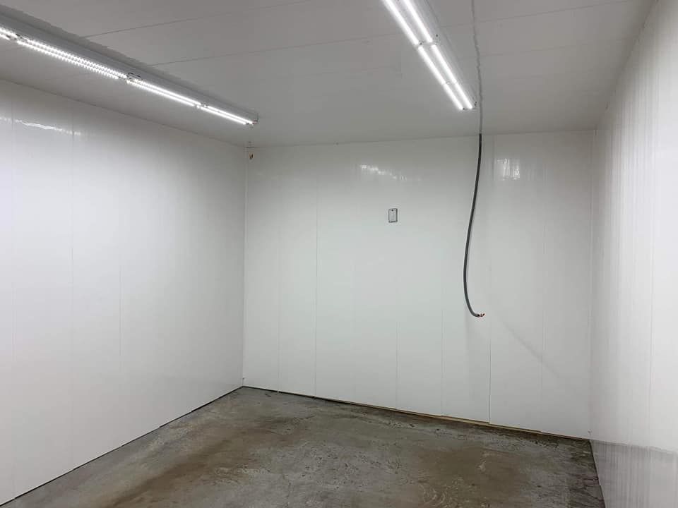 An empty room with white walls and a concrete floor.