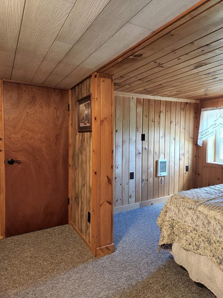 A bedroom with a bed and a picture on the wall