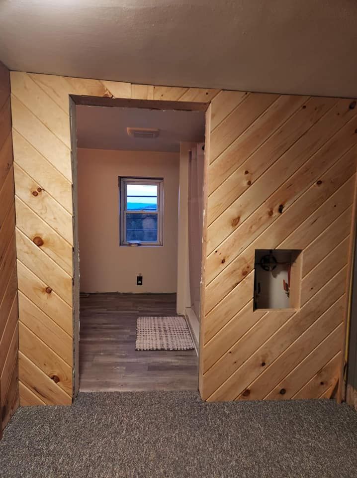 A room with a wooden wall and a window.