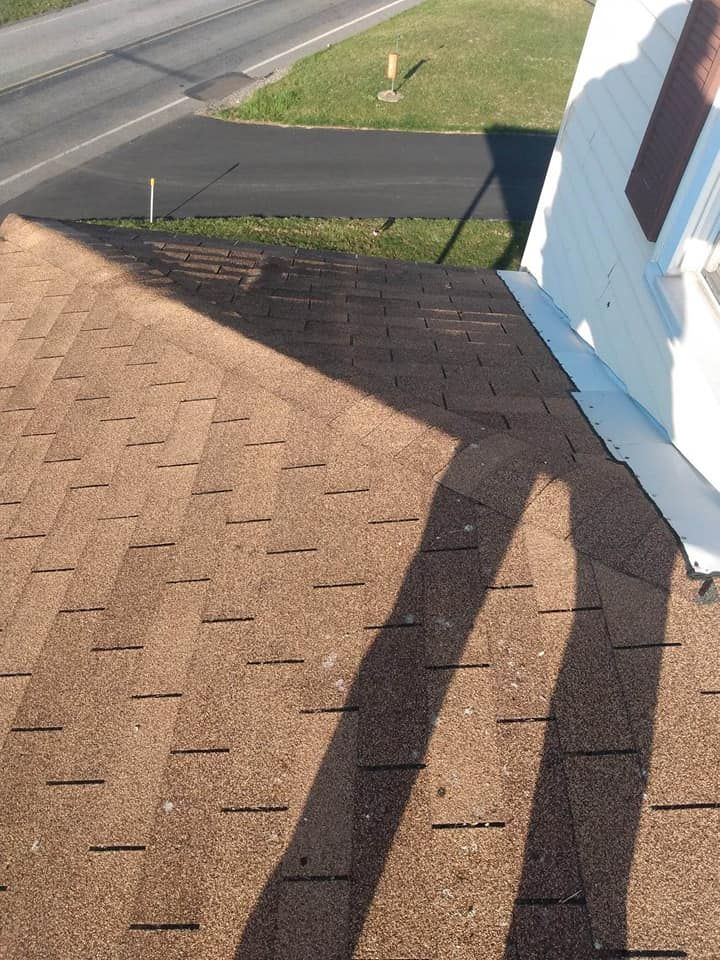 A shadow of a person is cast on the roof of a house