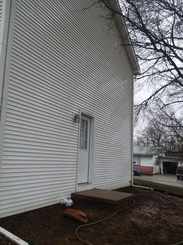 A house with a white siding and a white door