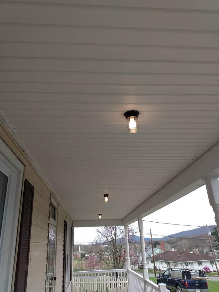 The ceiling of a porch with a light on it.