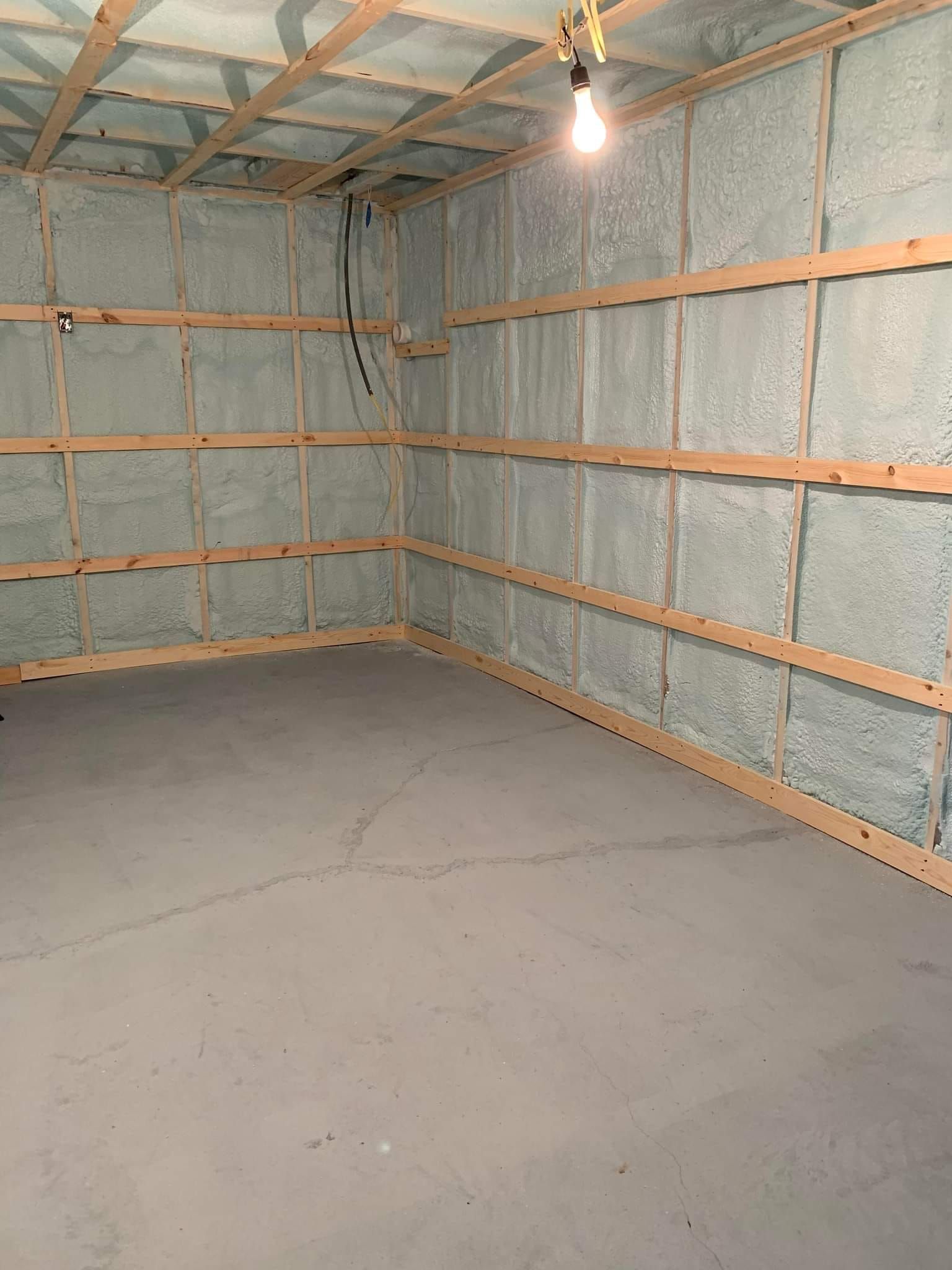 An empty room with a light hanging from the ceiling.