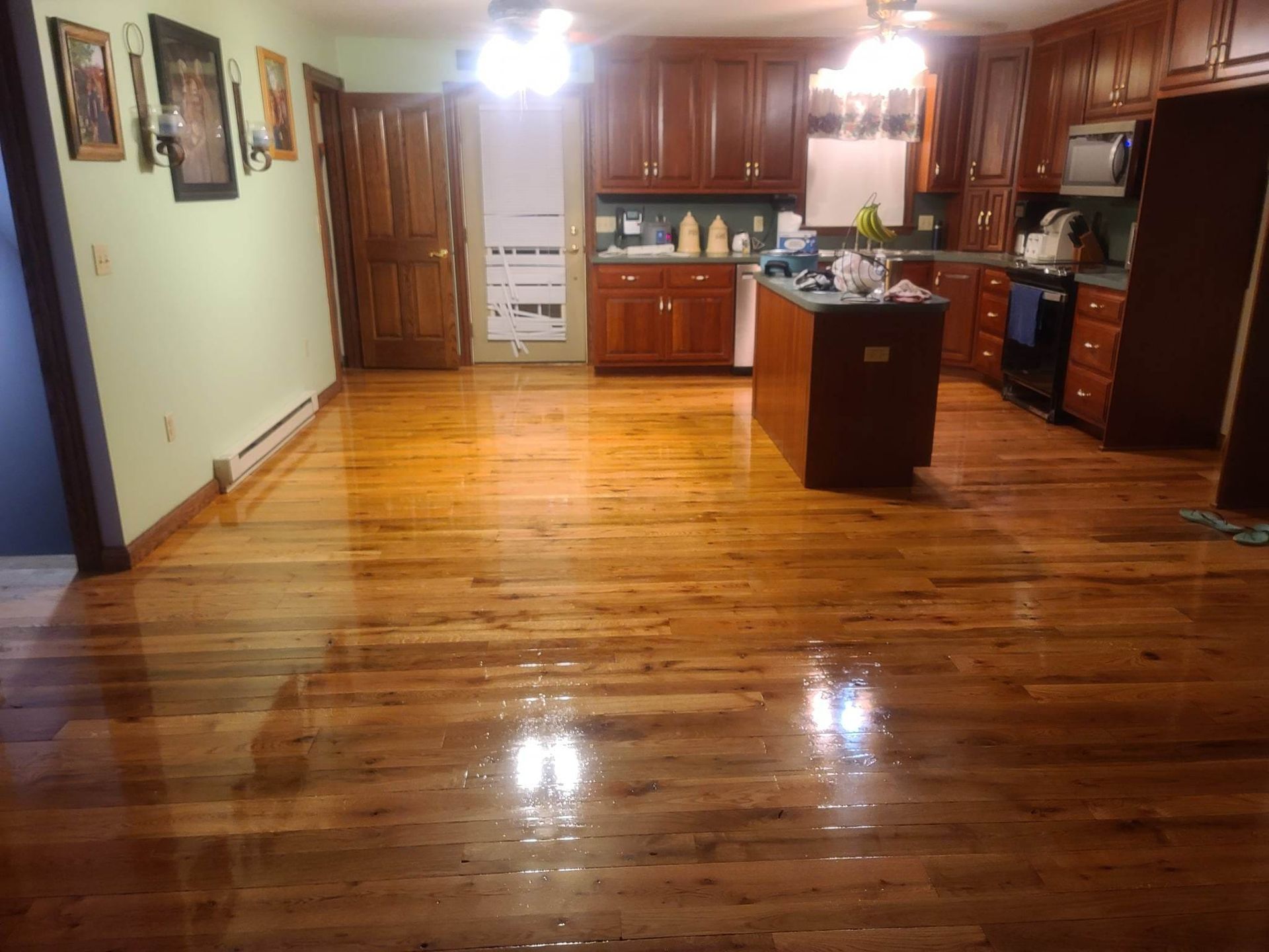 A kitchen with a wooden floor and cabinets