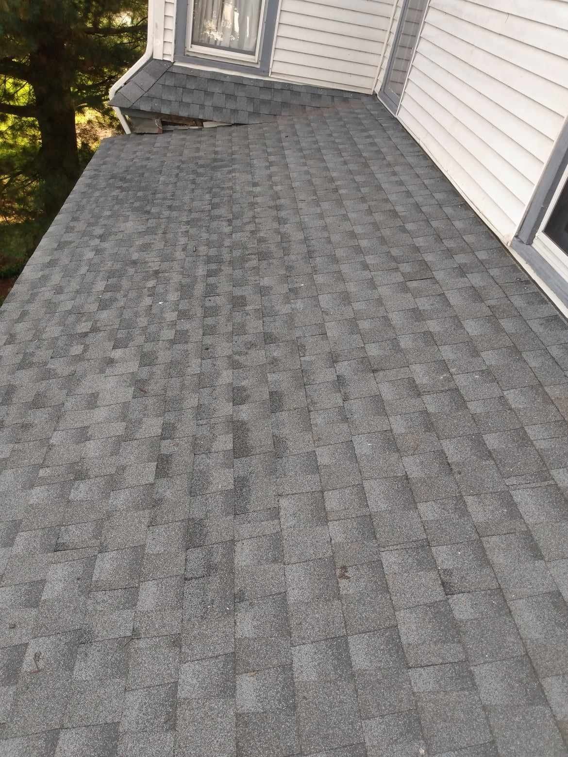 The roof of a house with a gray shingle roof.