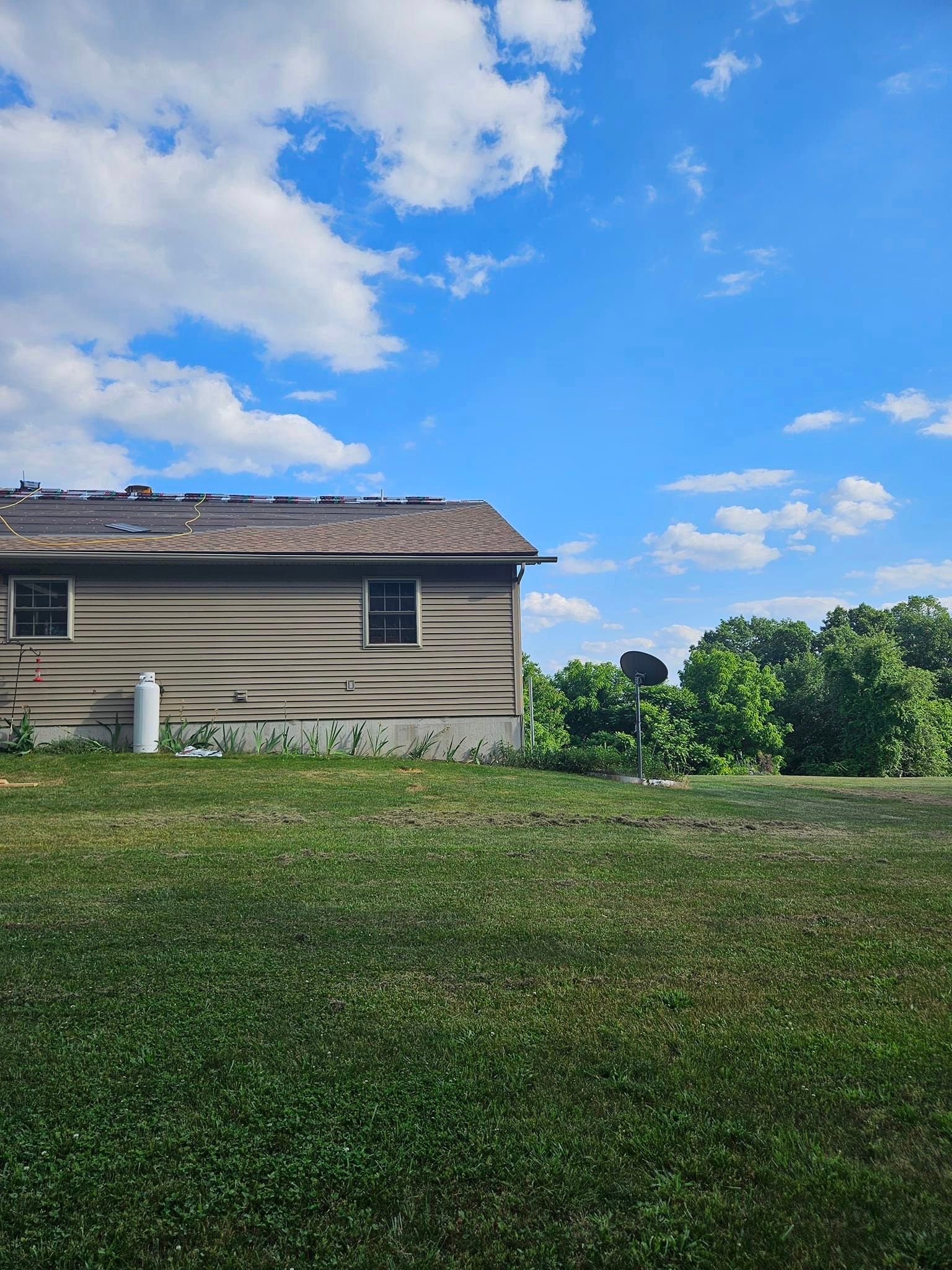 A log cabin is sitting in the middle of a lush green field.