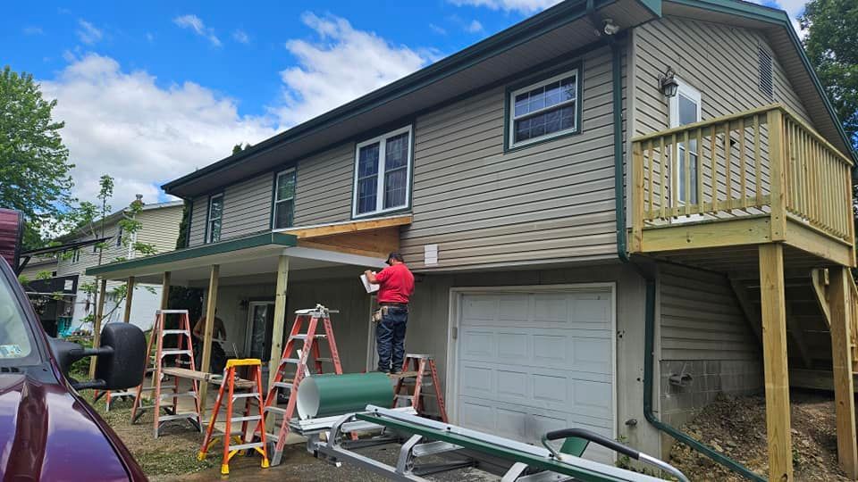 A man is standing on a ladder in front of a house.
