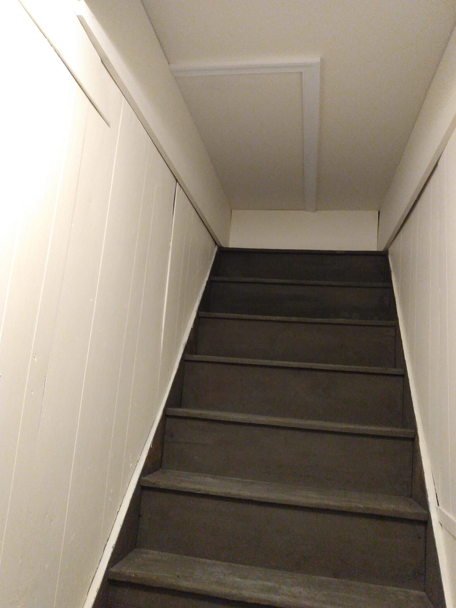 A set of stairs leading up to a white wall