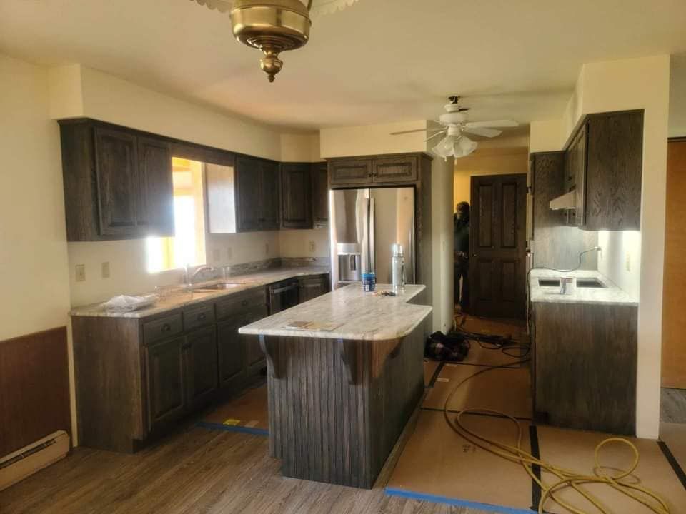 A kitchen with stainless steel appliances and a large island in the middle.