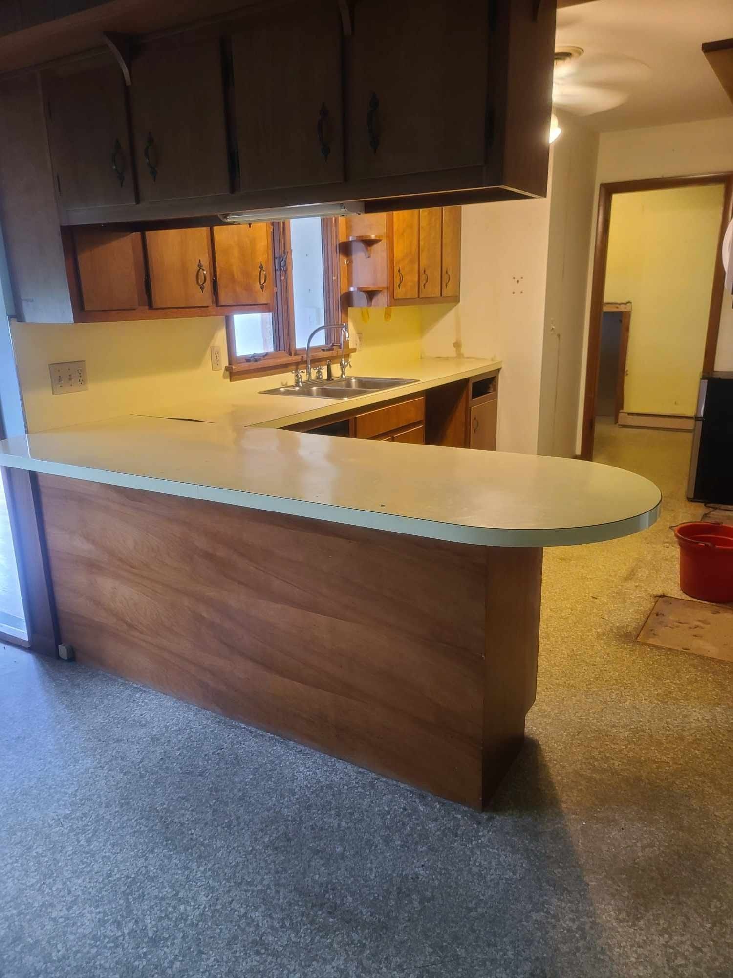 A kitchen with wooden cabinets and a white counter top