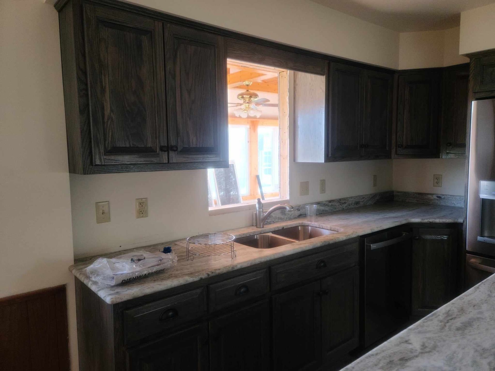 A kitchen with a sink , dishwasher , and refrigerator.