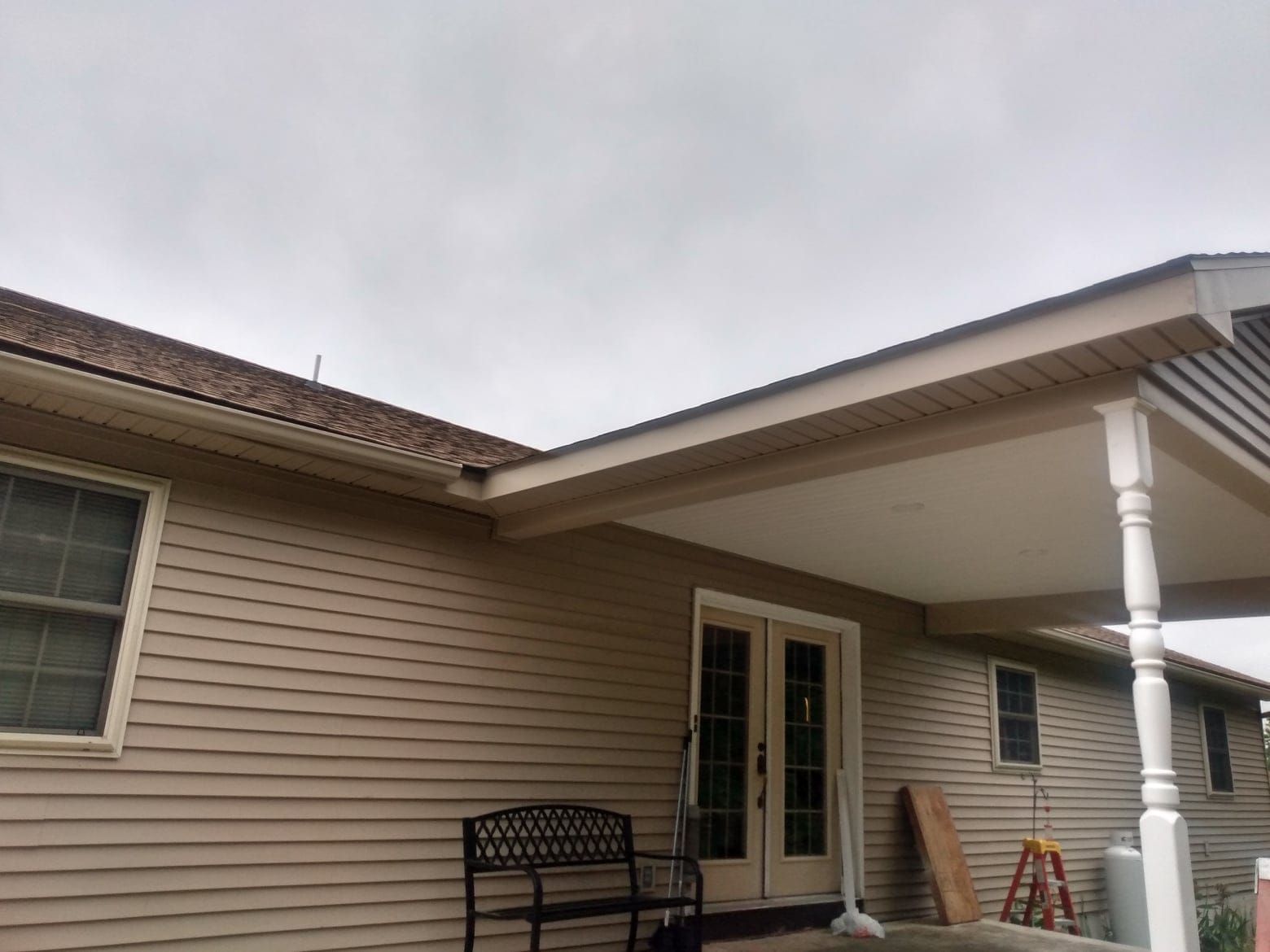 A house with a porch and a bench in front of it.