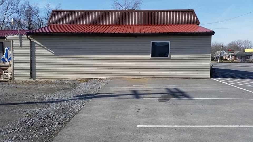 A building with a red roof is in a parking lot