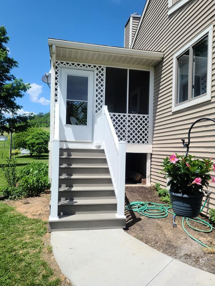 There is a screened in porch with stairs leading up to it.