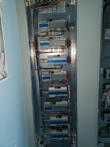 Electrical panel with rows of circuit breakers and wiring.
