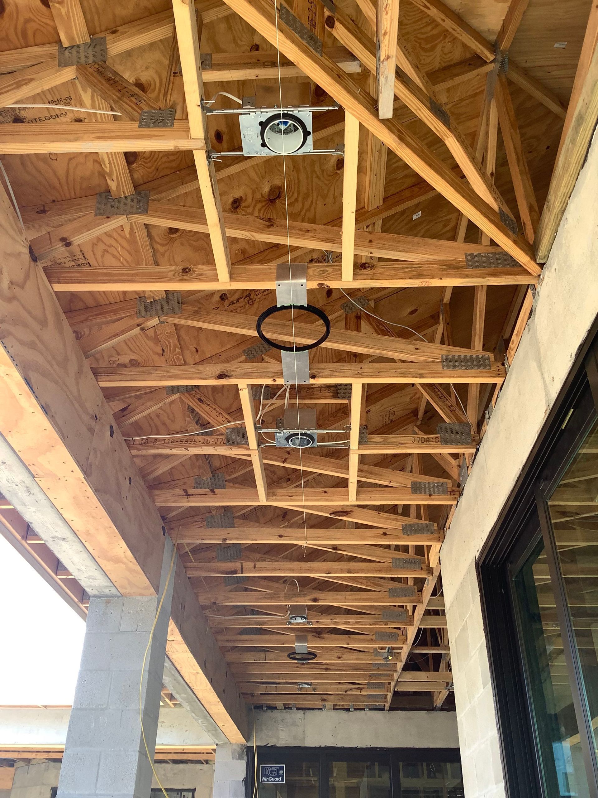 Wooden porch ceiling with recessed lighting and a basketball hoop.
