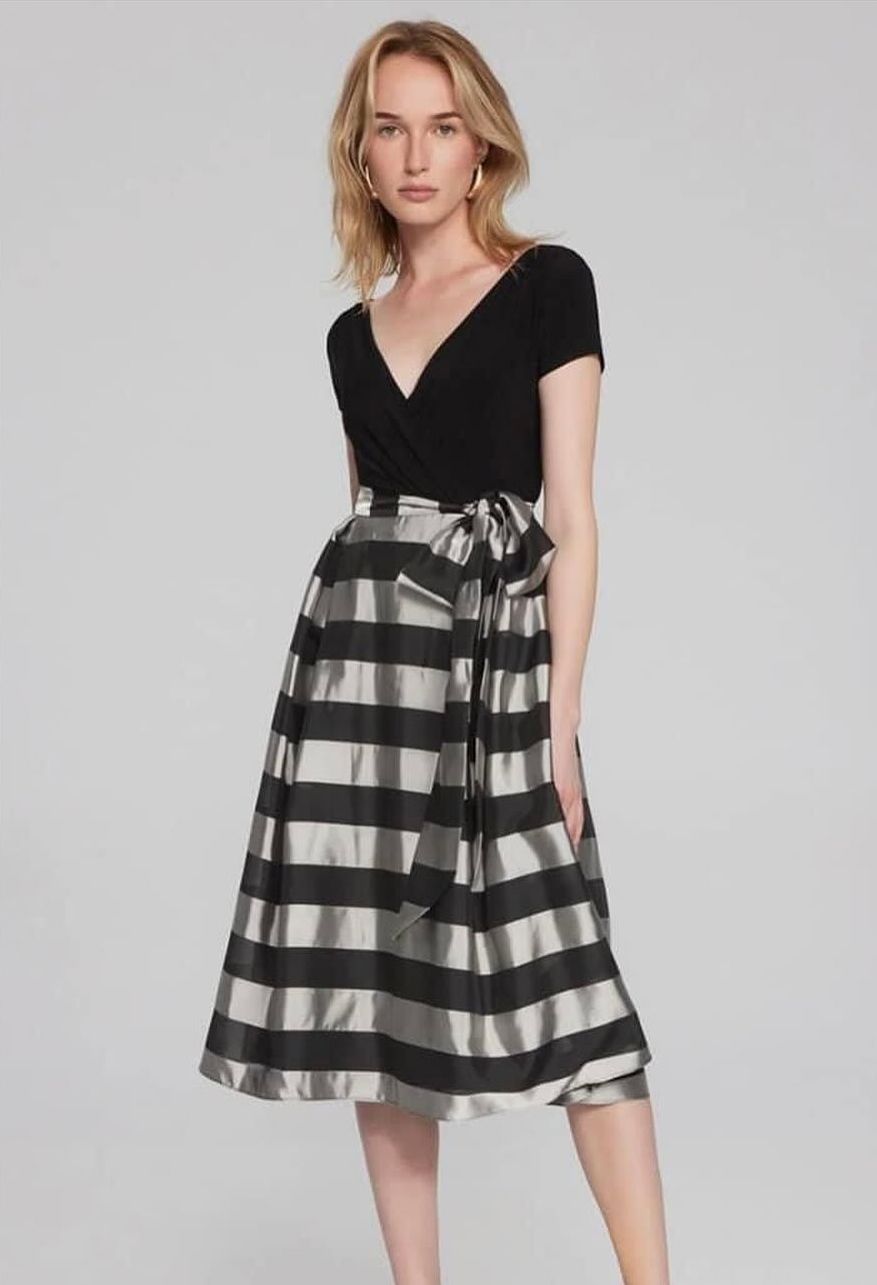 A woman is wearing a black and silver striped dress.