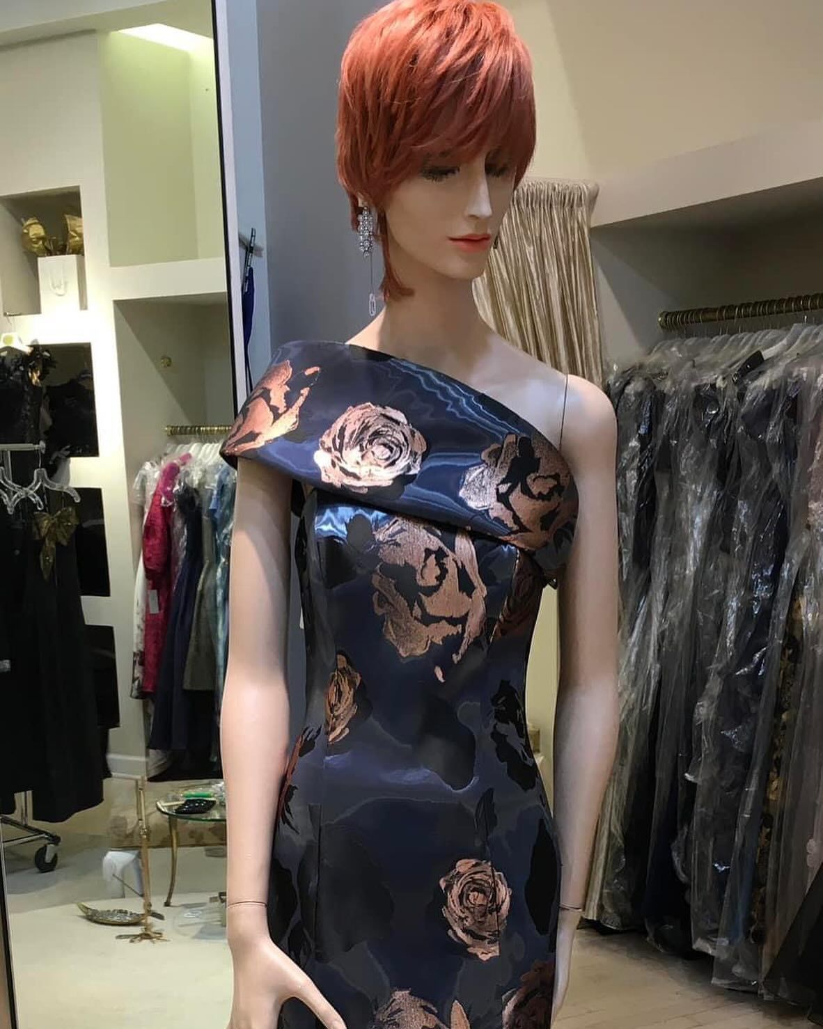 A mannequin with red hair is wearing a blue dress
