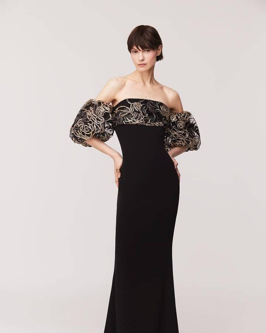 A woman is wearing a black dress with puffed sleeves.