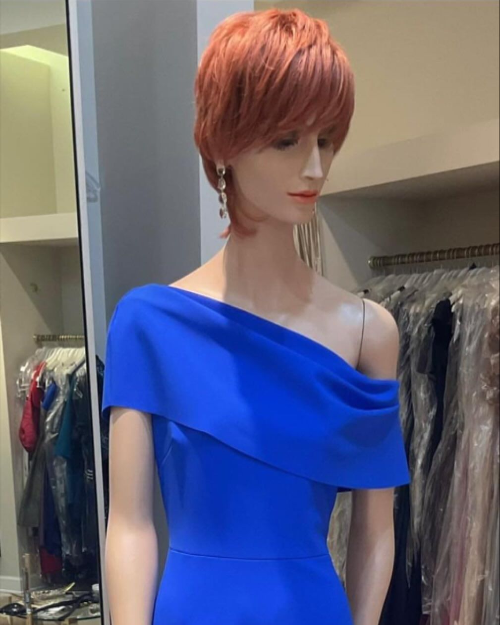 A mannequin with red hair is wearing a blue dress