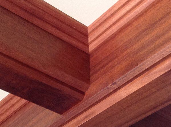 A close up of a corner of a wooden ceiling