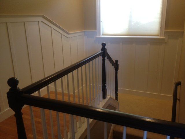 A staircase with a black railing and a window