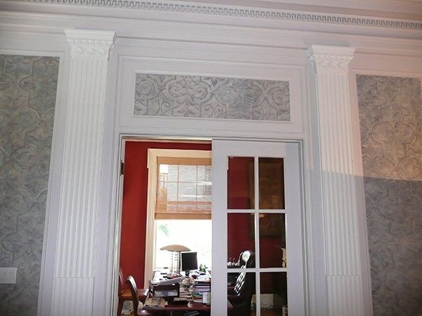 A room with white columns and a sliding glass door