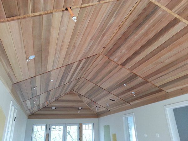 A room with a wooden ceiling and windows