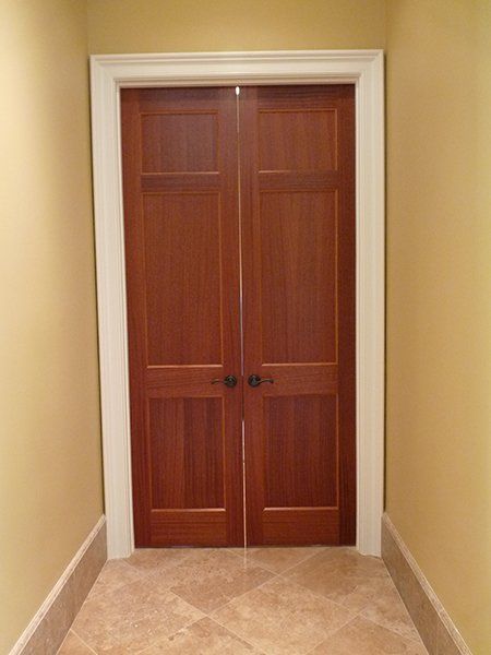 A hallway with a pair of wooden doors